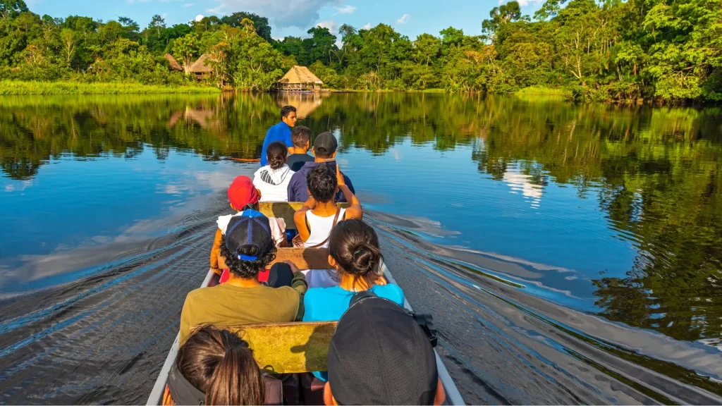 A tranquil river landscape in the Amazon Basin, surrounded by dense jungle vegetation.