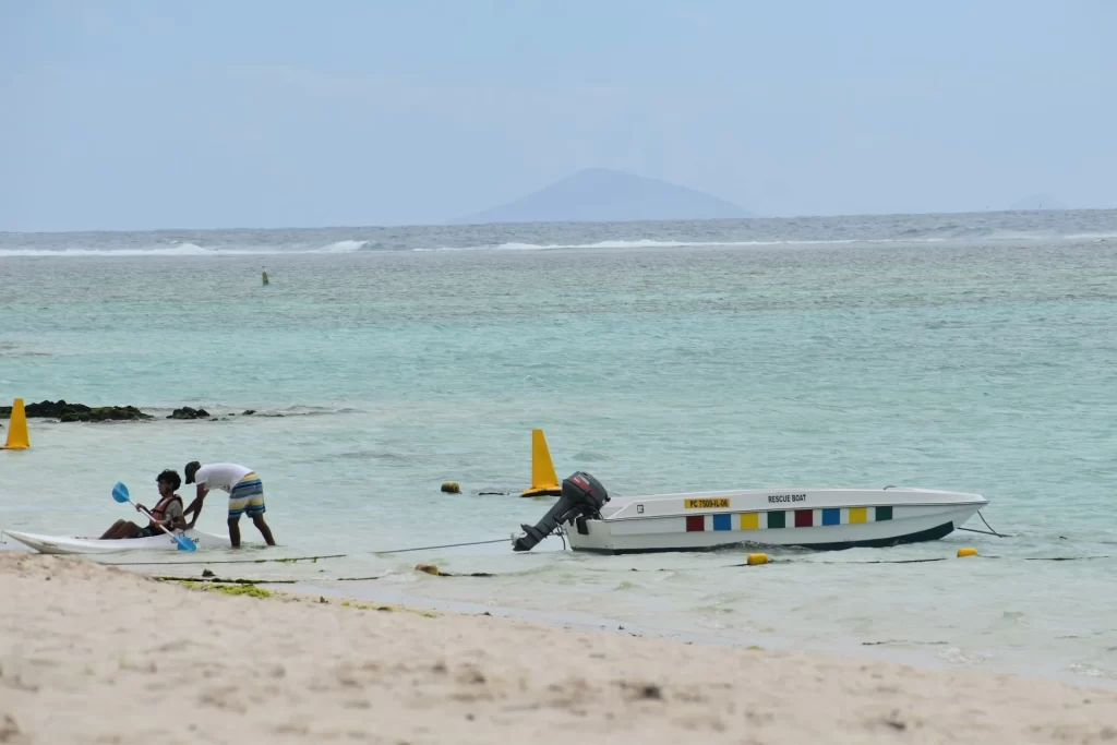A beached boat sits peacefully on the shore at Belle Mare, Mauritius — where turquoise waters meet soft sand and tropical calm. - Darwin islands visited