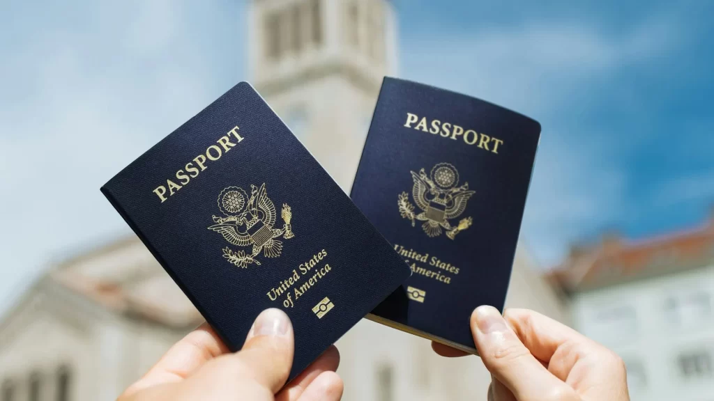Two people holding U.S. passports in front of a building, representing travel or immigration. - US citizens travel Galapagos