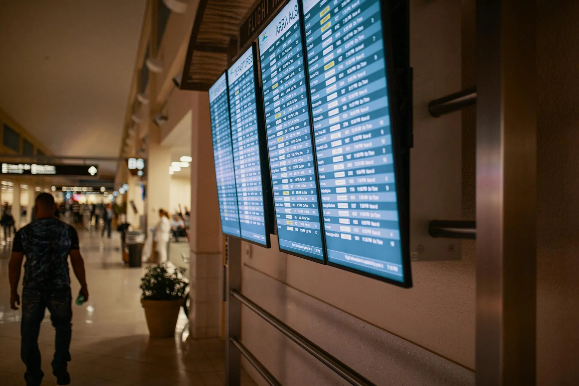 Flat-screen monitors displaying airline flight schedules and departure times at an airport terminal. Foto de Josh Sorenson