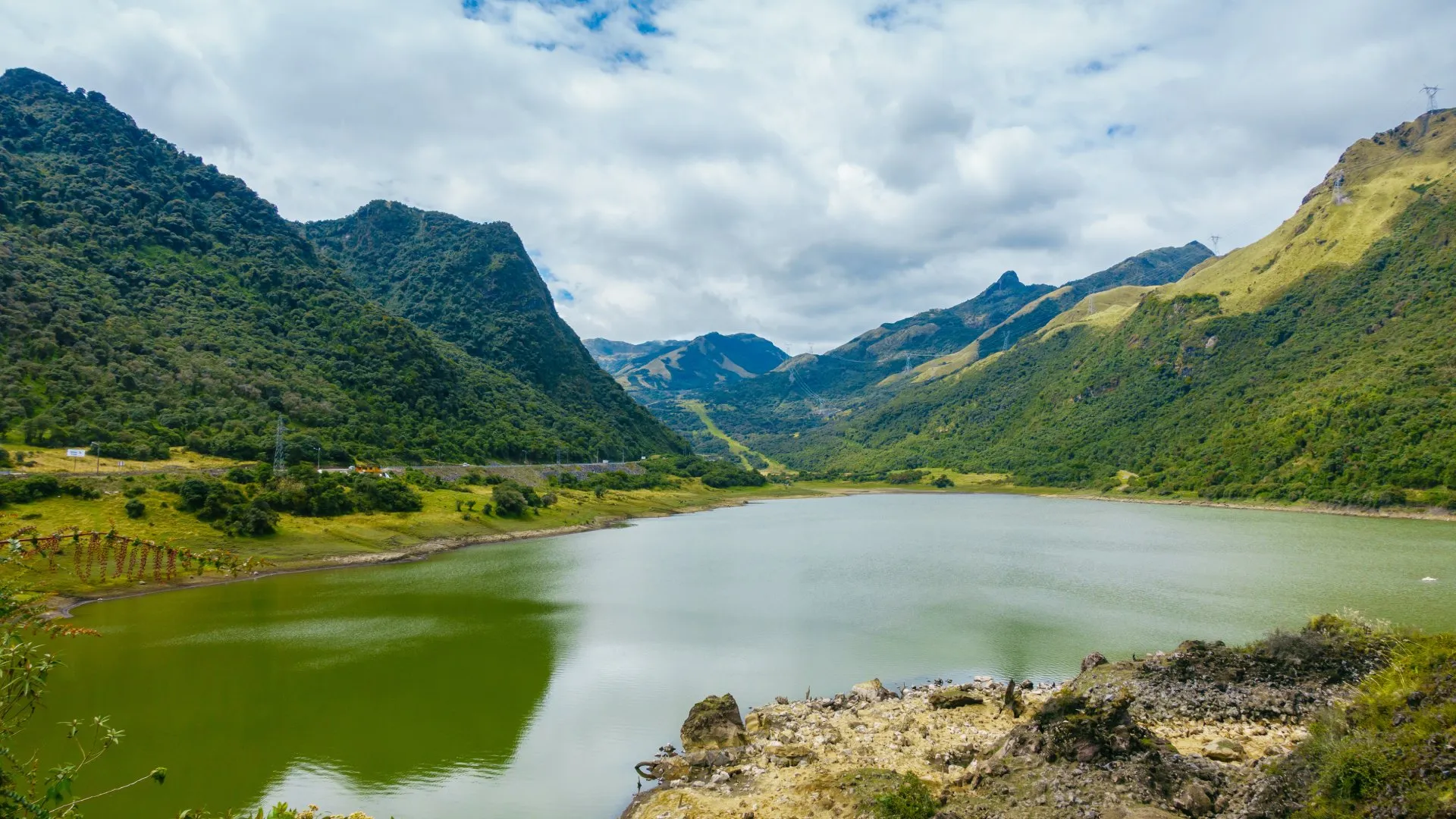 Laguna de Papallacta, a high-altitude volcanic crater lake in the Ecuadorian Andes, surrounded by páramo vegetation.