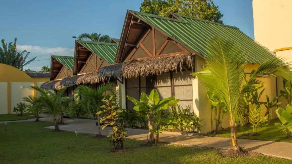 Row of green-roofed bungalows surrounded by tropical gardens at Amazon Bed & Breakfast, Leticia, Colombia.