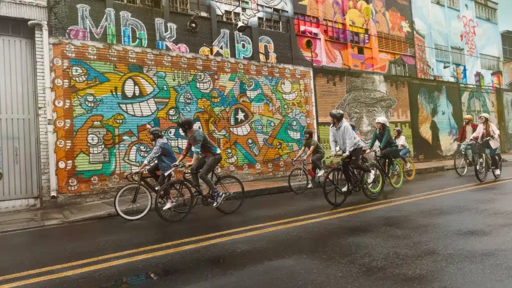 Cyclists riding through the Graffiti District in Bogotá-art in Bogotá