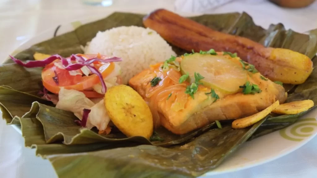 Fish fillet served on a banana leaf with rice, salad, and fried plantain-Colombian Gastronomy