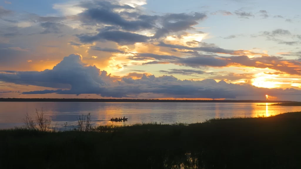 Canoes sailing under a golden sunset on the Amazon-tourism in Colombia’s Amazon