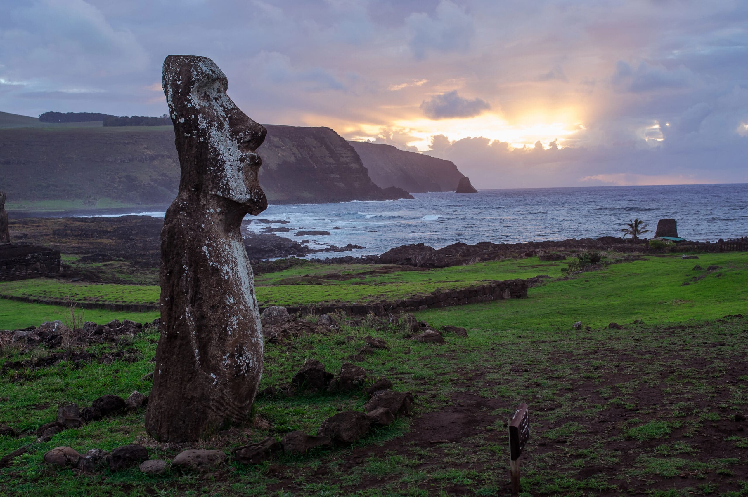 Easter Island stone giants represented by a solitary moai overlooking the Pacific Ocean at sunset.