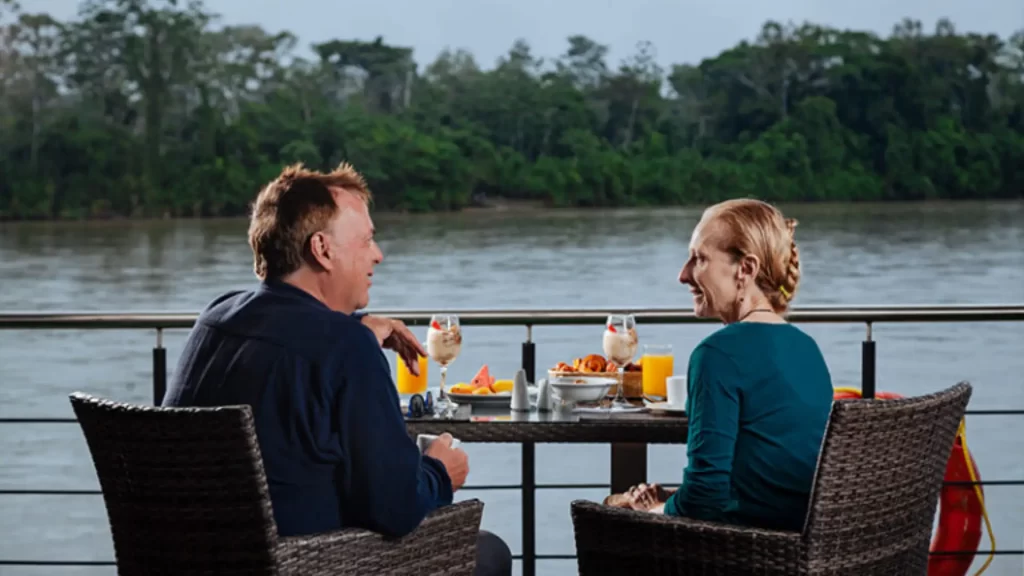 Couple enjoying a romantic dinner by the river in the Ecuadorian Amazon, one of the most intimate romantic places in Latin America
